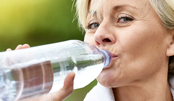 Frau trinkt Wasser Venenleiden vorbeugen